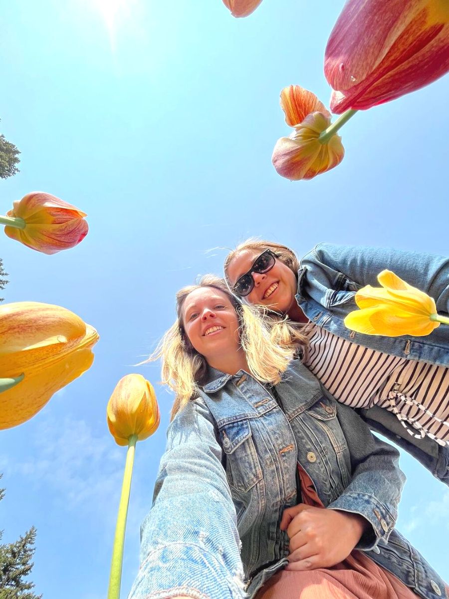 Two girls smiling with tulips blooming