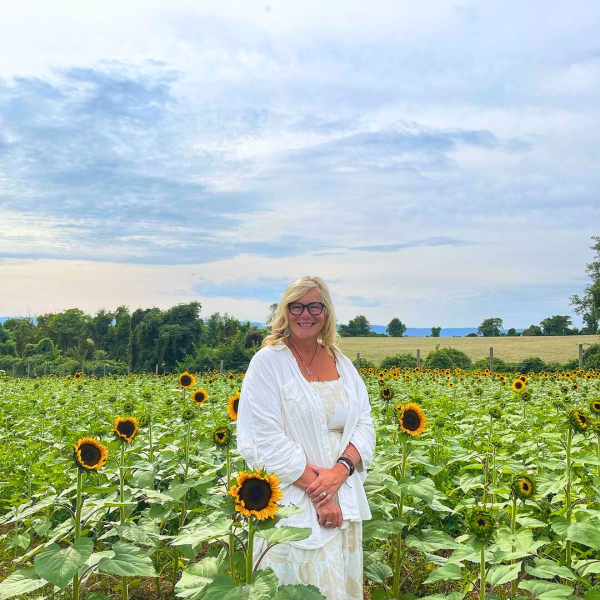 Holly Chapple surrounded by sunflowers in her farm